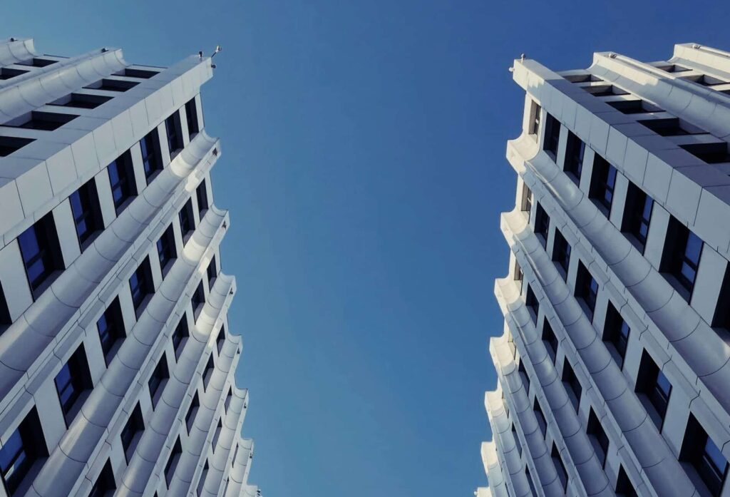 Explore striking modern skyscrapers with a symmetrical design under a clear blue sky.